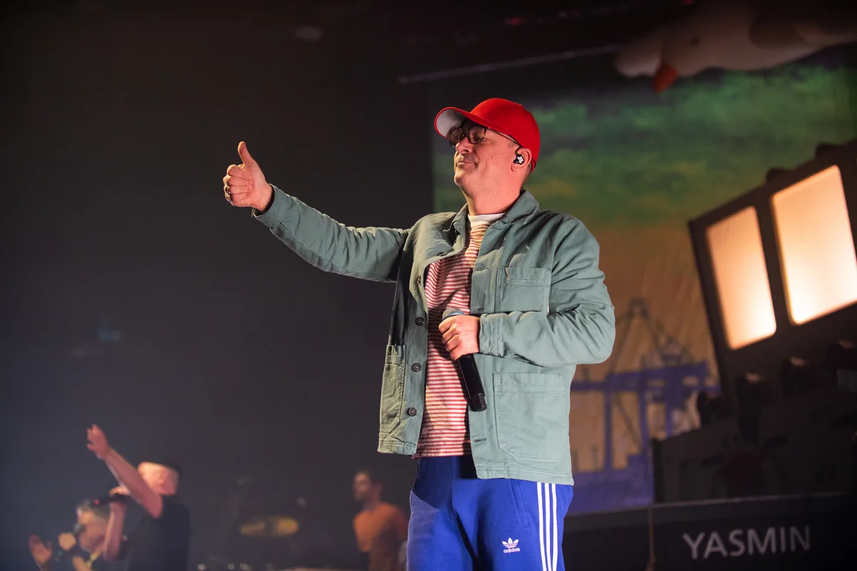 Mann mit Brille und roter Kappe auf der Bühne.